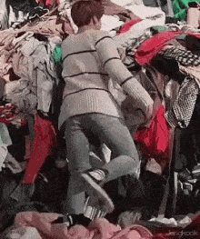 laying in piles of clothes gif